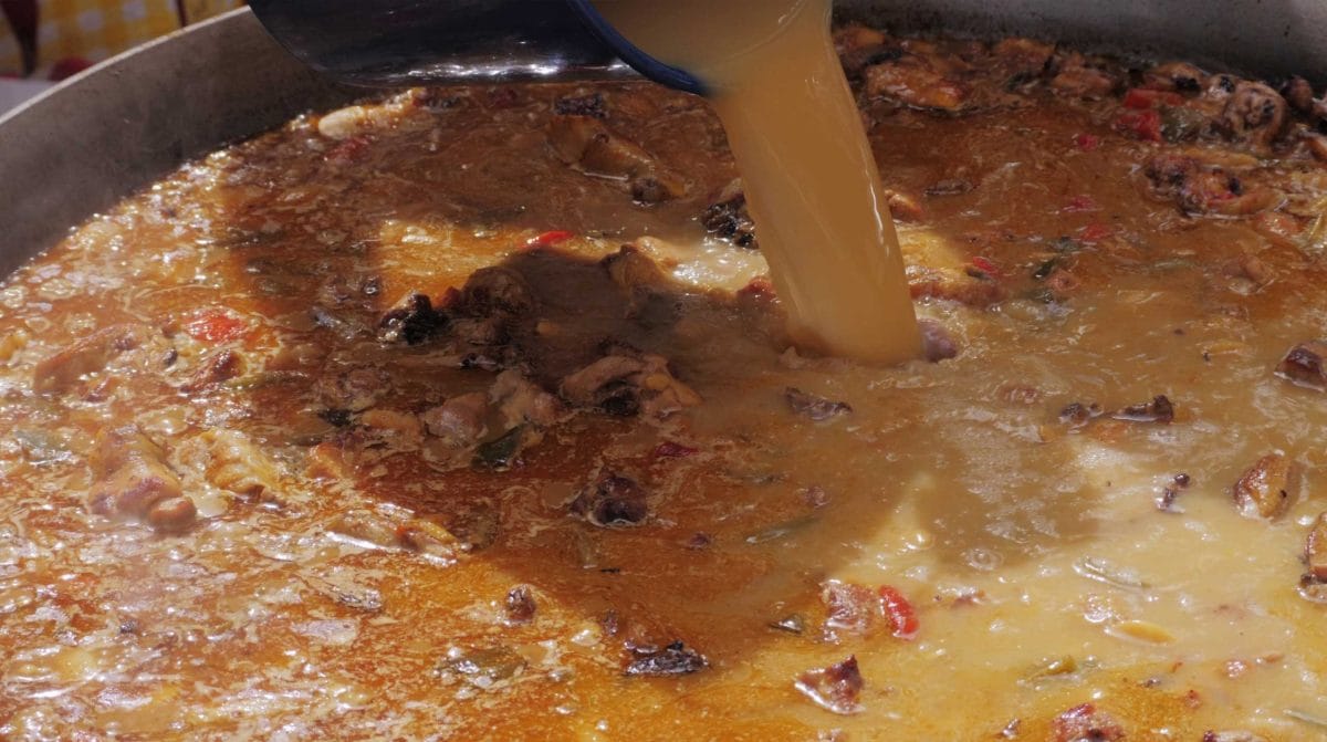 Le bouillon est versé dans la poêle à paëlla